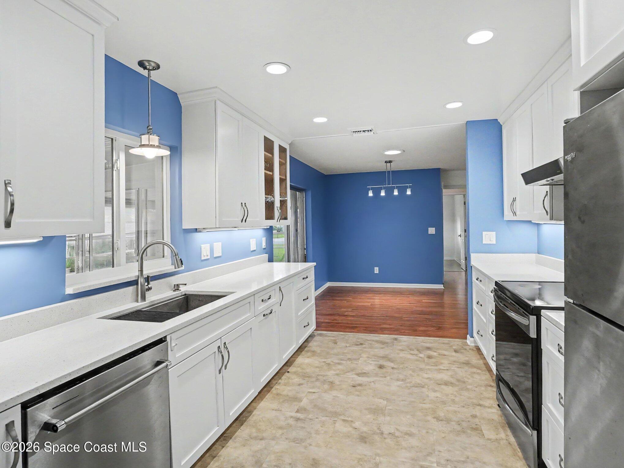 1870 Tallpalm Road Melbourne, FL 32935 - Photo 12 of 30 a large kitchen with stainless steel appliances granite countertop a sink and a refrigerator