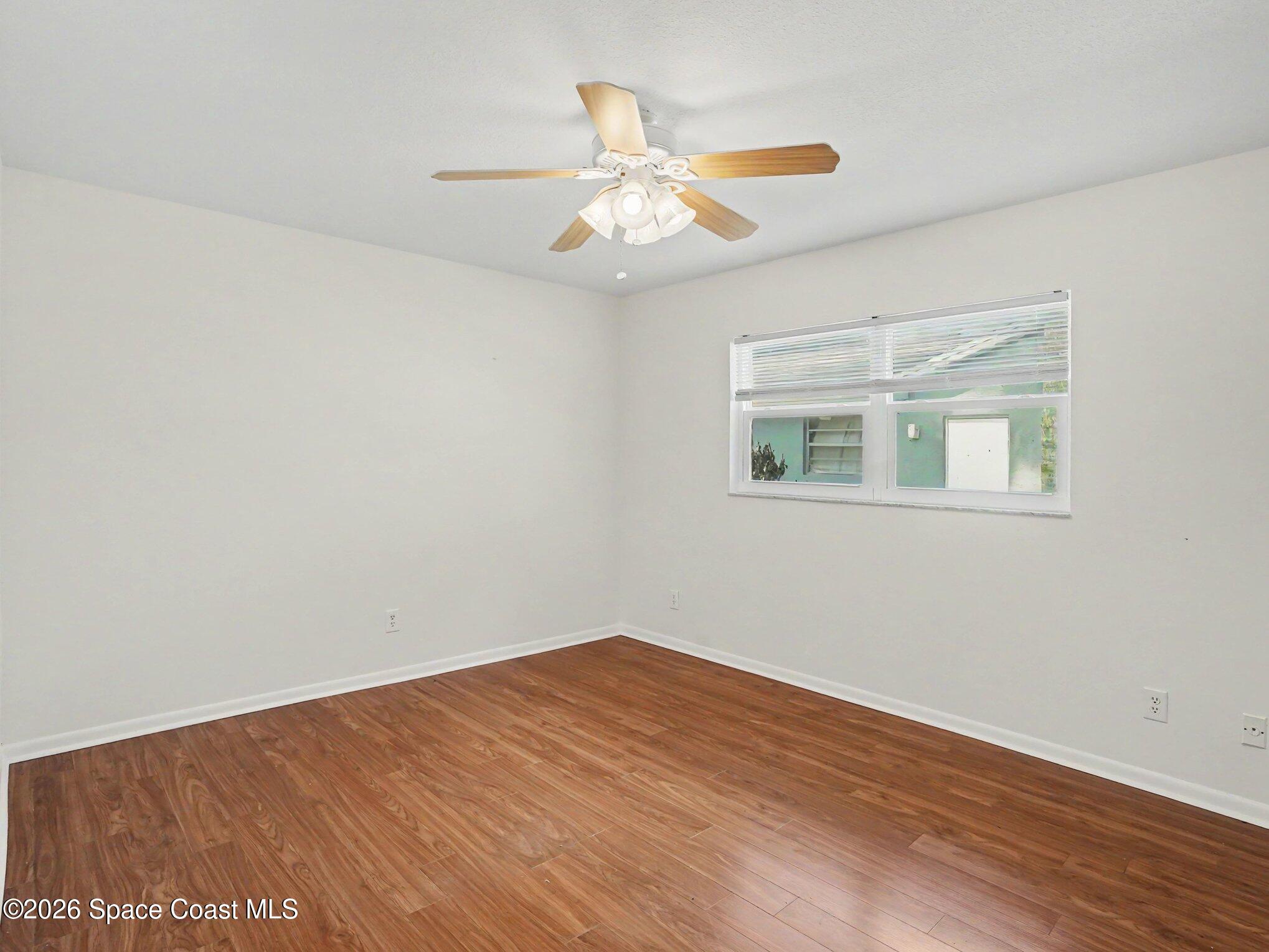 1870 Tallpalm Road Melbourne, FL 32935 - Photo 15 of 30 a view of an empty room with wooden floor and a window
