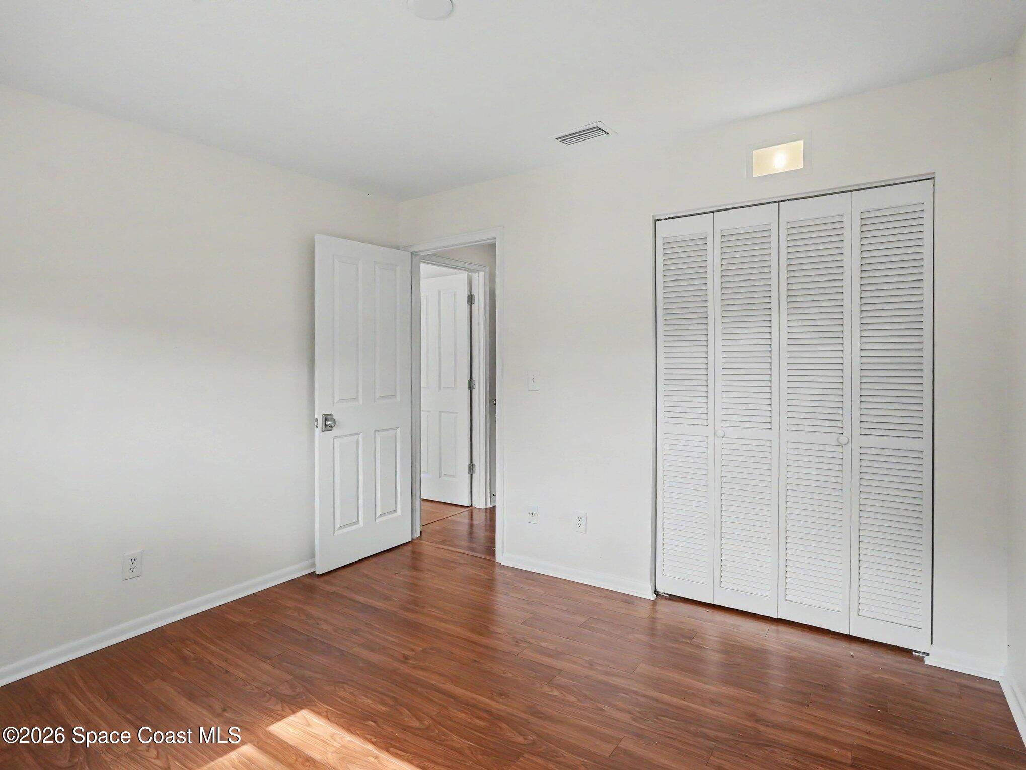1870 Tallpalm Road Melbourne, FL 32935 - Photo 19 of 30 a view of an empty room with wooden floor and closet