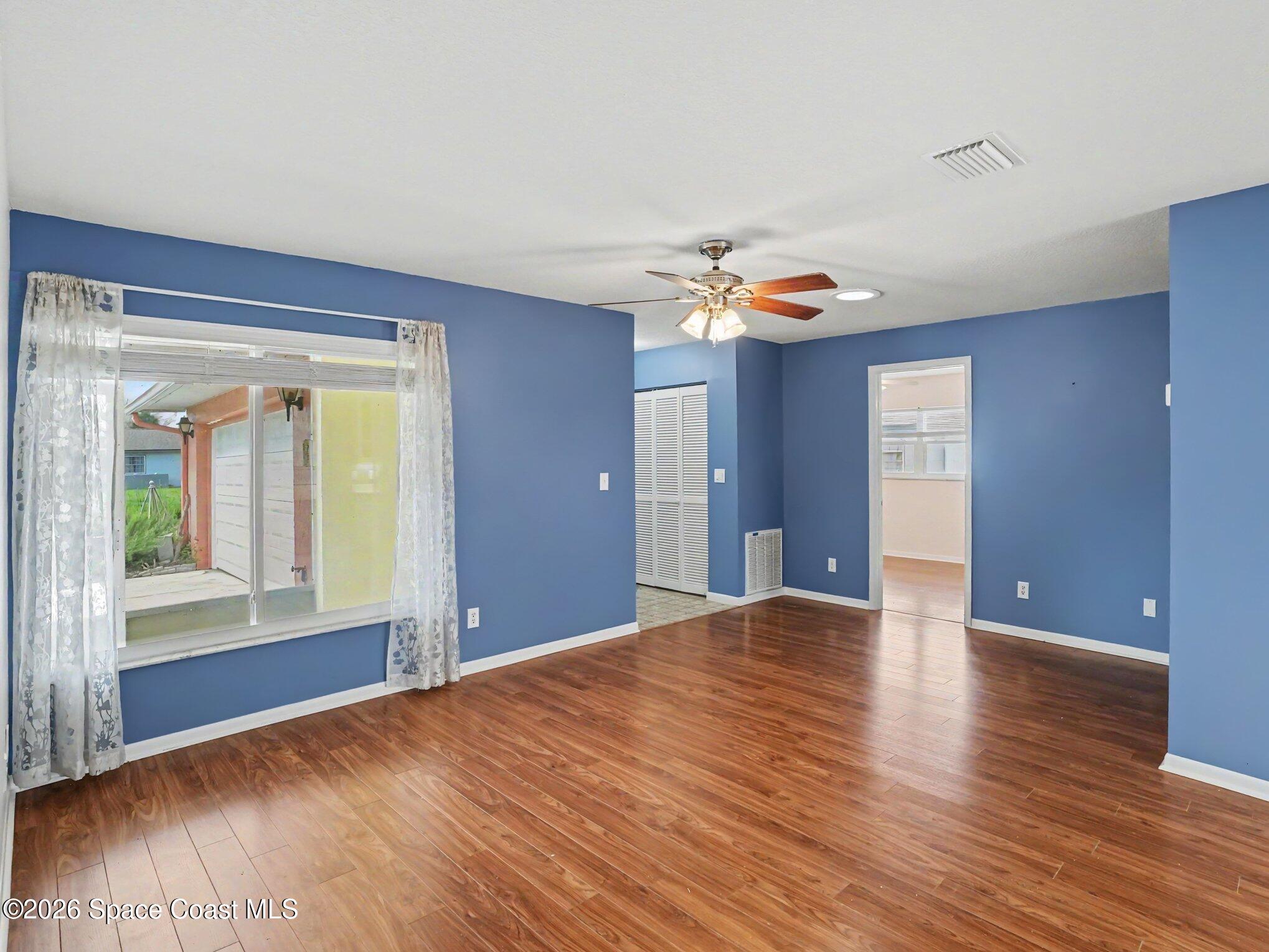 1870 Tallpalm Road Melbourne, FL 32935 - Photo 5 of 30 a view of an empty room with wooden floor and a window