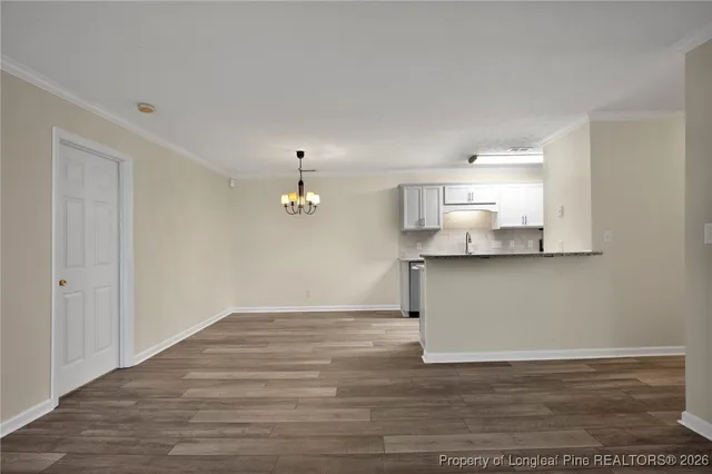 a view of empty room with wooden floor and fireplace
