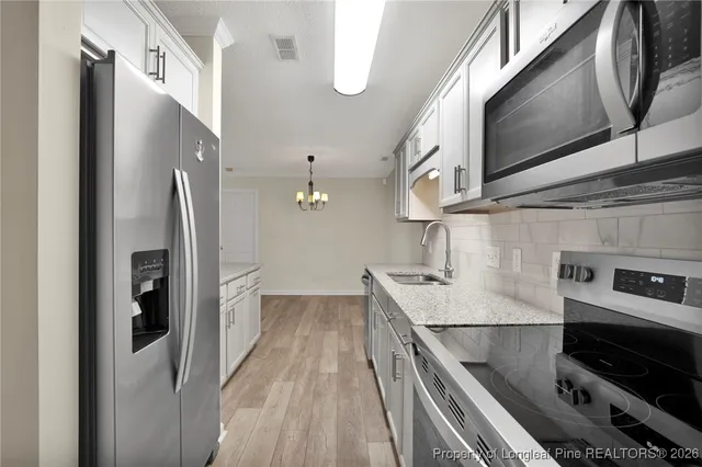 a kitchen with stainless steel appliances granite countertop a refrigerator and a sink