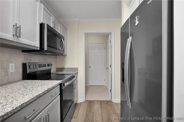 a kitchen with white cabinets and stainless steel appliances