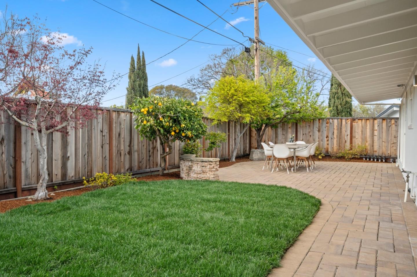 238 Hamilton Avenue Mountain View, CA 94043 - Photo 17 of 18 a view of a backyard with table and chairs with wooden fence and plants