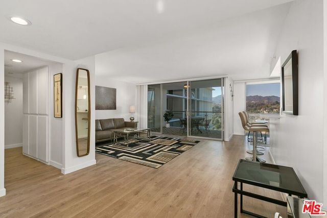 a living room with furniture a flat screen tv and a floor to ceiling window