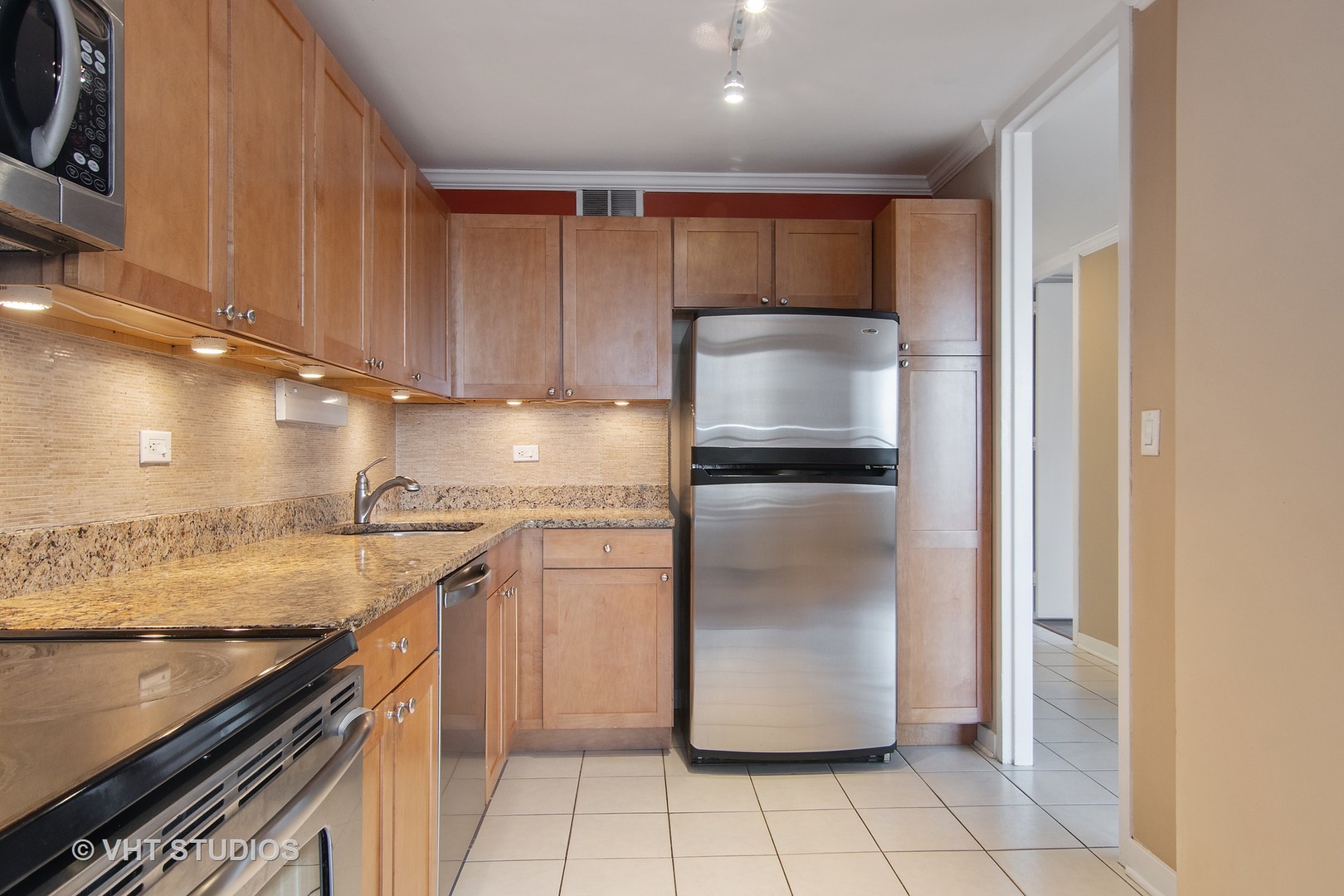 655 West Irving Park Road, Unit 910 Chicago, IL 60613 - Photo 7 of 14 a kitchen with a refrigerator sink and cabinets