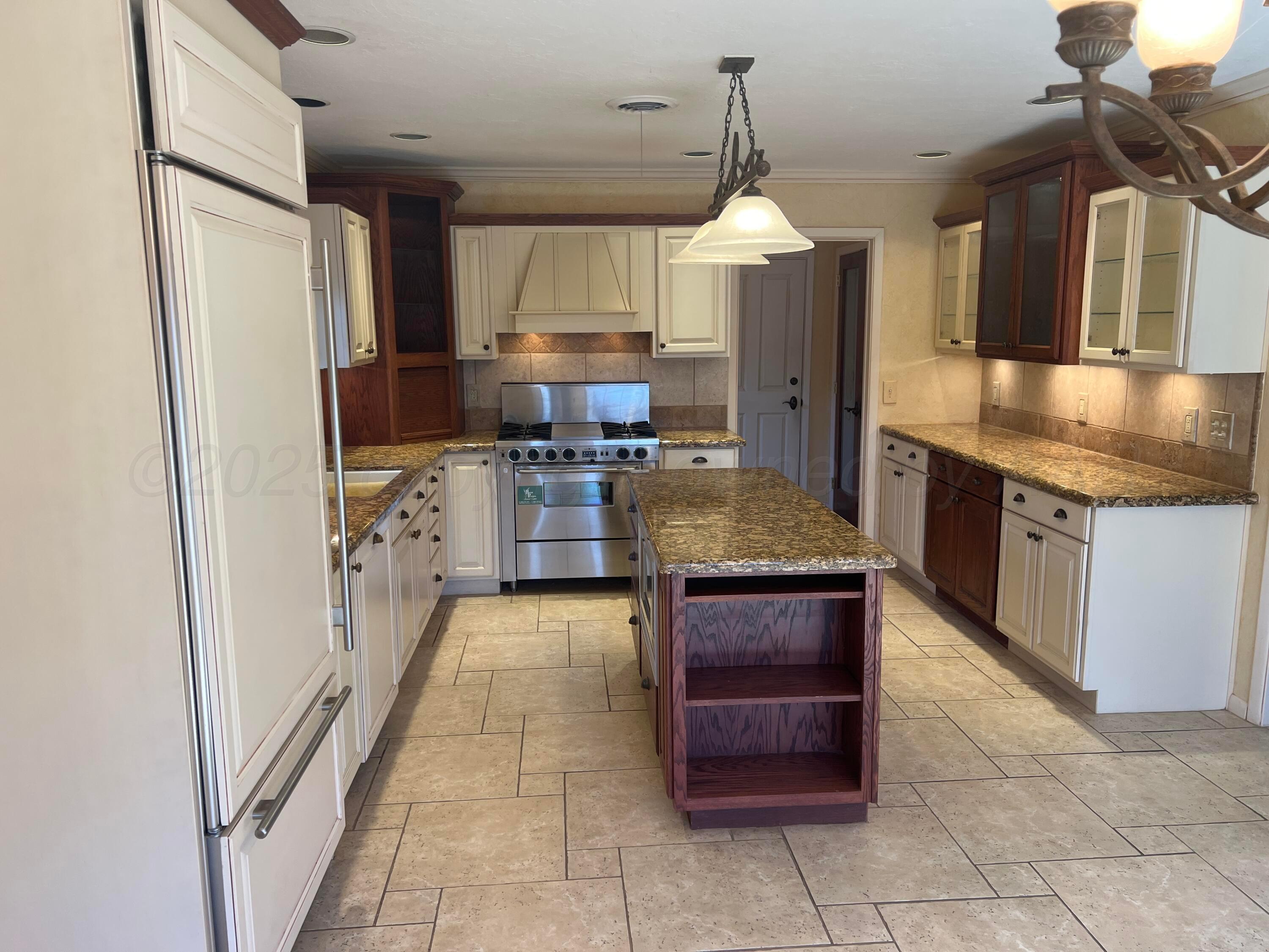 7115 Gainsborough Road Amarillo, TX 79106 - Photo 12 of 81 a large kitchen with a stove a refrigerator and a sink