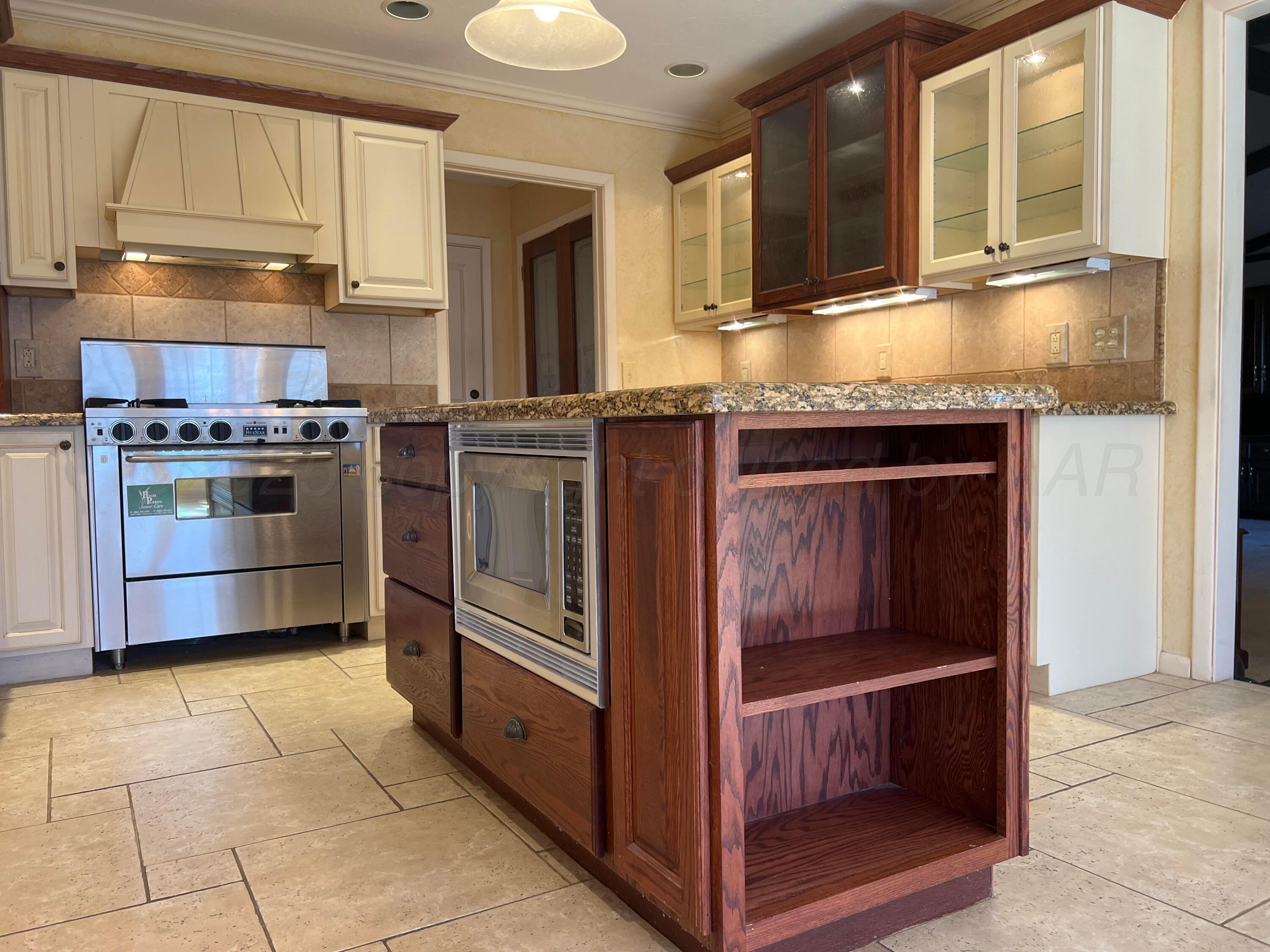 7115 Gainsborough Road Amarillo, TX 79106 - Photo 13 of 81 a kitchen with granite countertop a stove and a sink