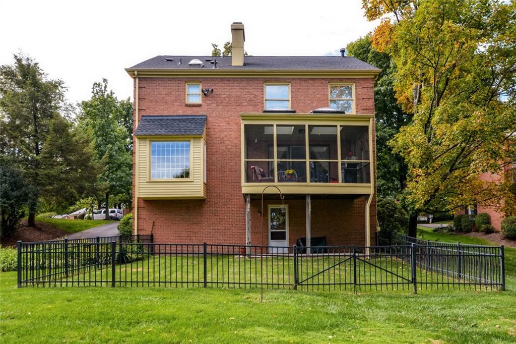 Exterior Rear View: Fenced yard area for pets and children. Block patio under screen porch. Two sky lights on screen porch. Bump out window area in kitchen with panoramic view. 