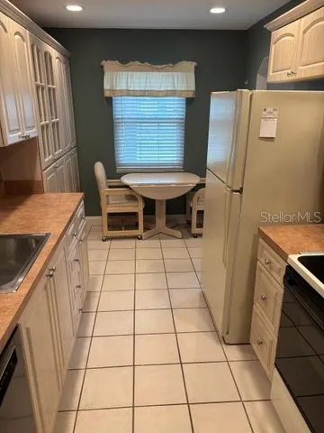 a view of a kitchen with fridge and wooden floor