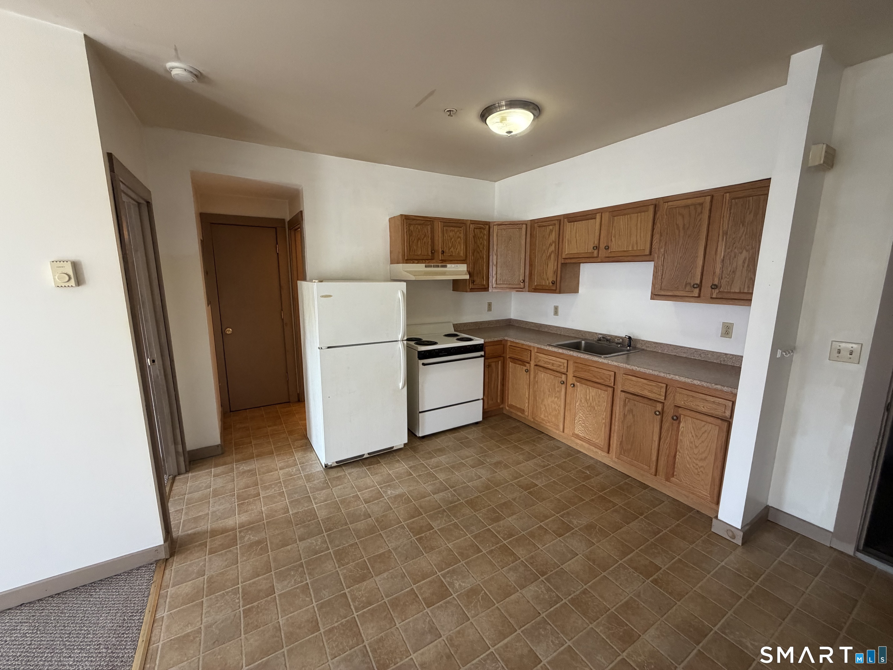 277 North Main Street, Unit 3 Winchester, CT 06098 - Photo 5 of 14 a kitchen with white cabinets and white appliances