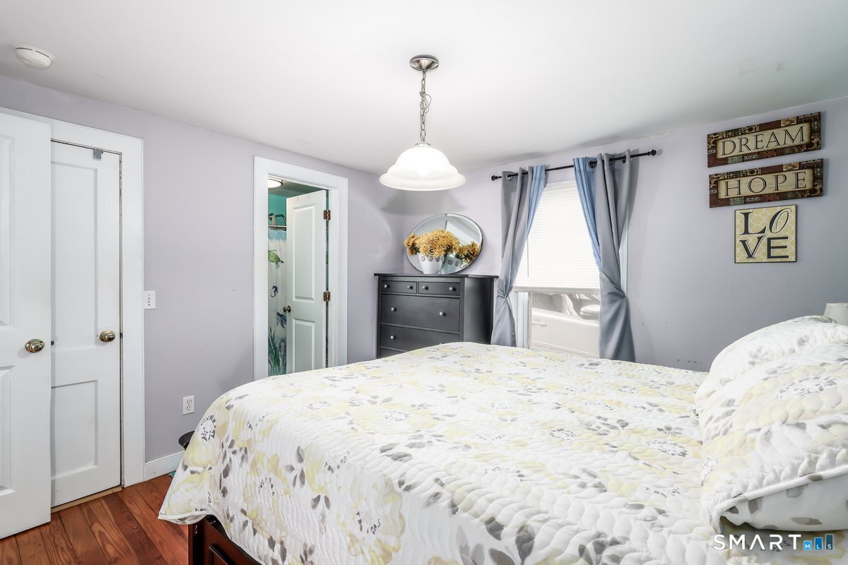 70 Dodgingtown Road Bethel, CT 06801 - Photo 19 of 27 a bedroom with a bed and a chandelier