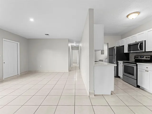 a kitchen with white cabinets a sink and stainless steel appliances