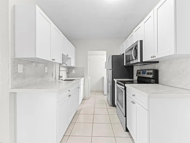 a kitchen with stainless steel appliances granite countertop a sink and a stove