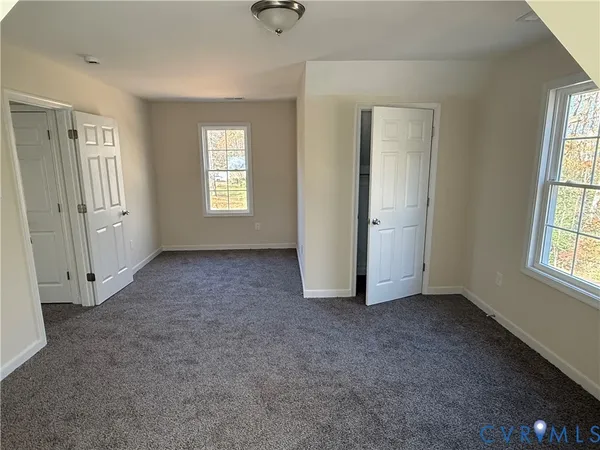 an empty room with windows and closet