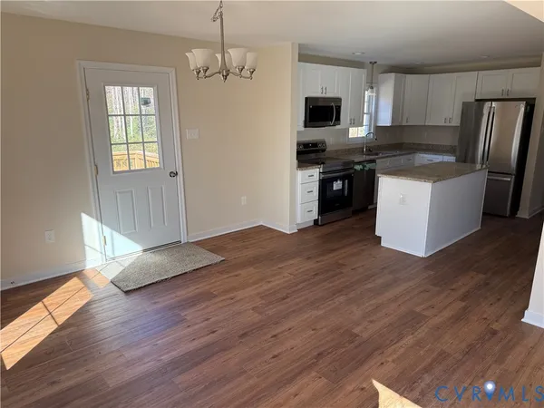 a kitchen with granite countertop a refrigerator stove top oven and sink