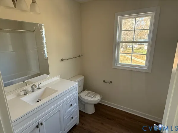 a bathroom with a sink toilet and window