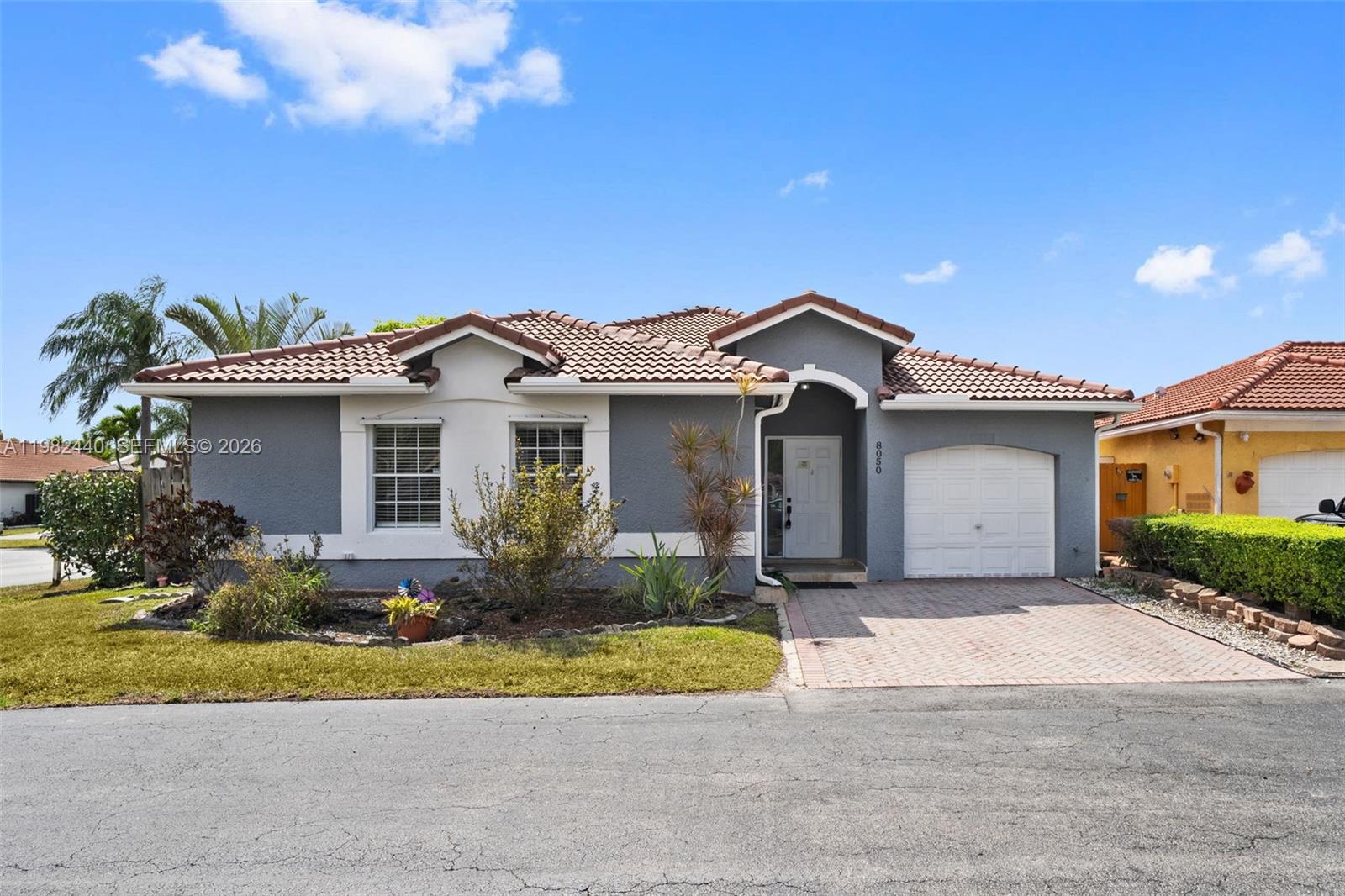 8050 Southwest 157th Place Miami, FL 33193 - Photo 1 of 12 a front view of a house with a yard and garage