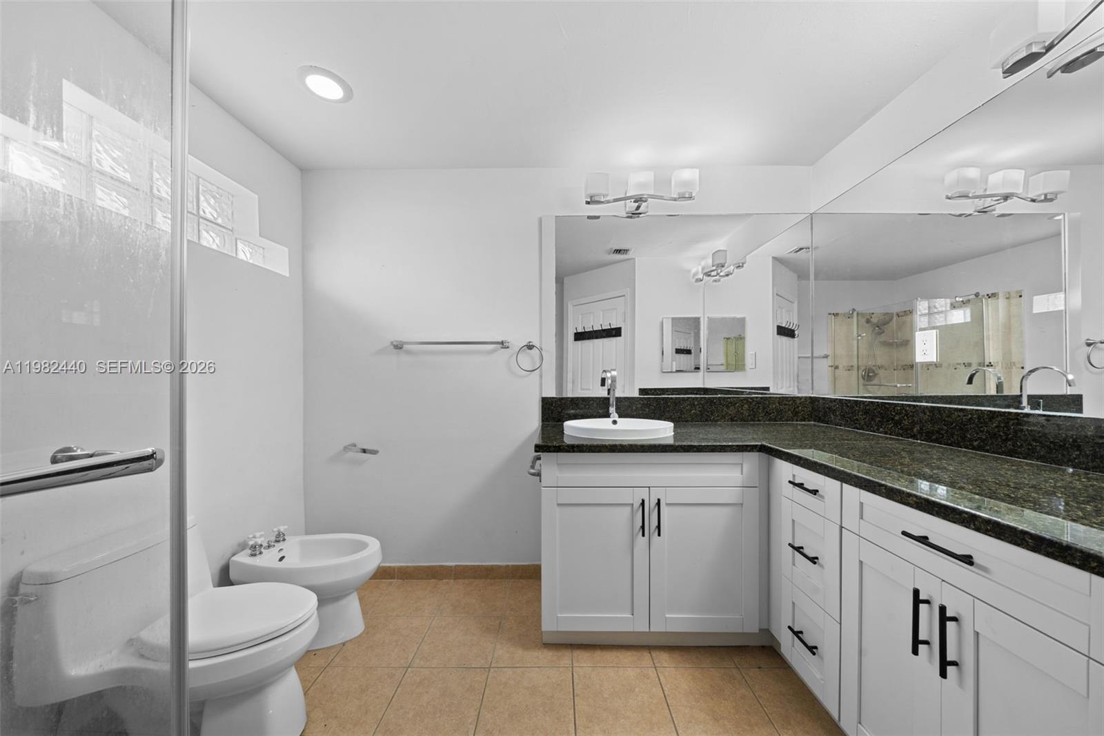 8050 Southwest 157th Place Miami, FL 33193 - Photo 11 of 12 a spacious bathroom with a granite countertop sink a toilet and a mirror