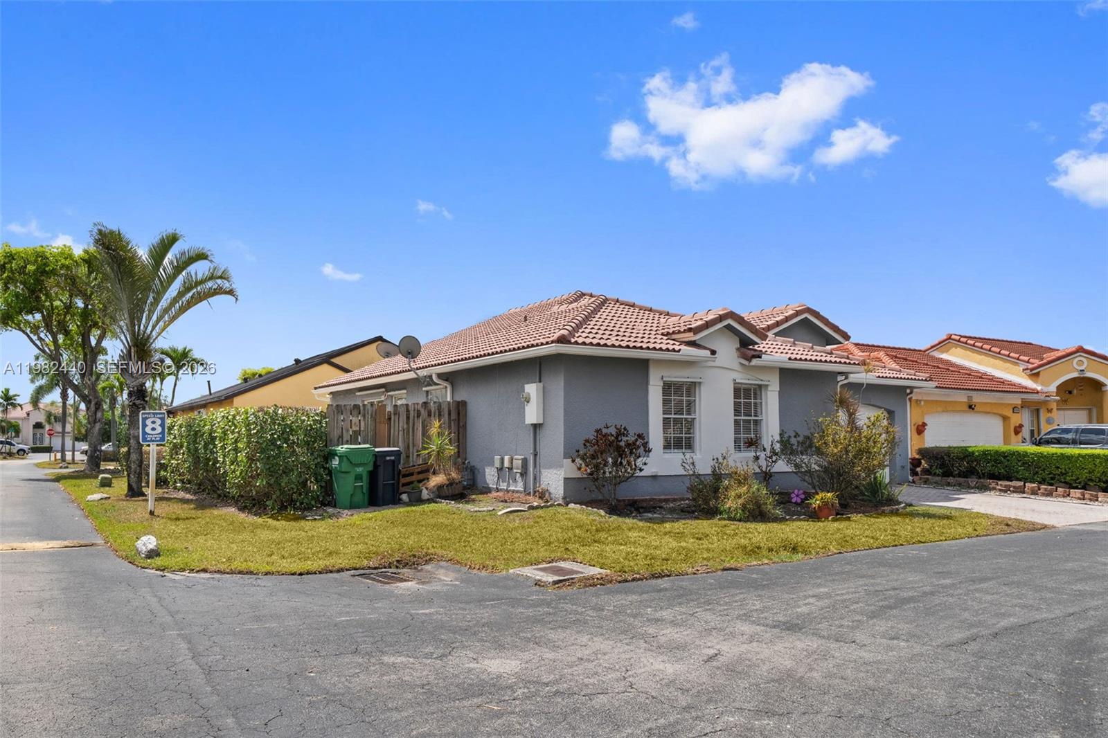 8050 Southwest 157th Place Miami, FL 33193 - Photo 2 of 12 a view of a white house with a big yard and potted plants