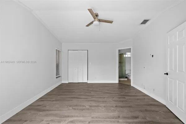a view of empty room with wooden floor