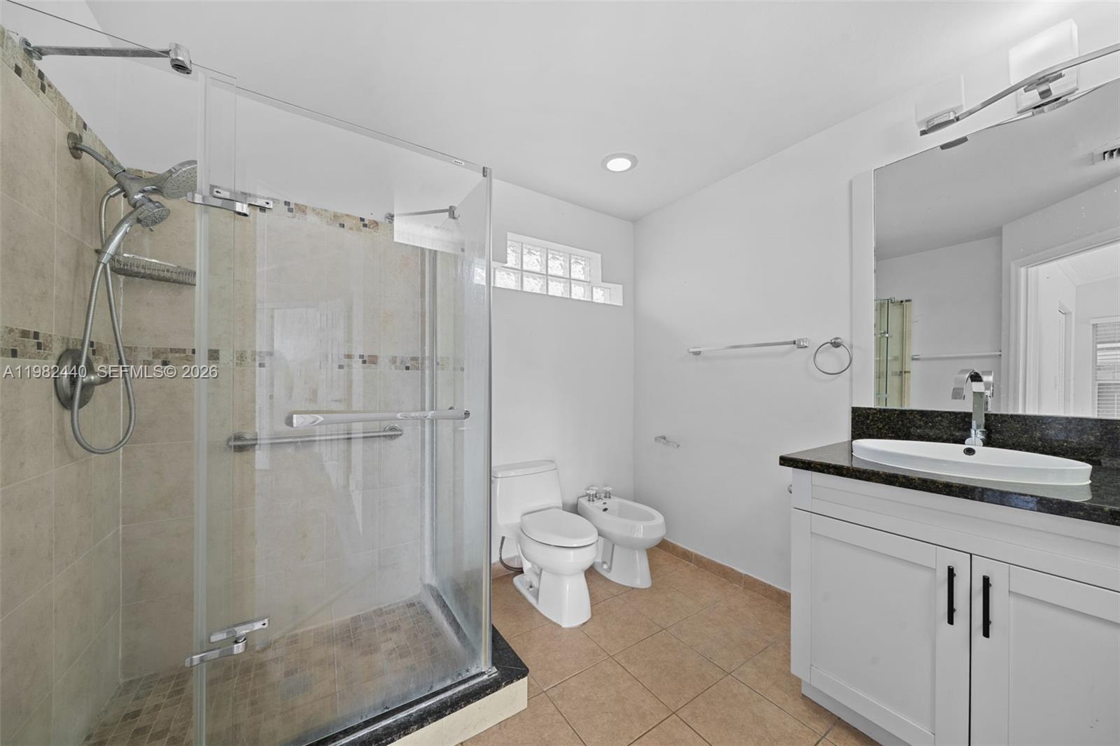 8050 Southwest 157th Place Miami, FL 33193 - Photo 10 of 12 a bathroom with a granite countertop sink a toilet and shower