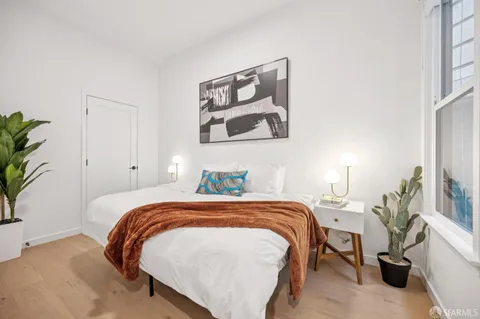 a bedroom with a bed and a potted plant