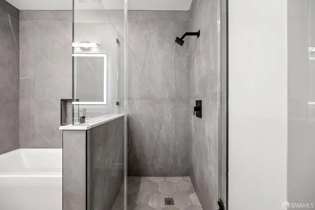 a bathroom with a sink a mirror a shower and vanity