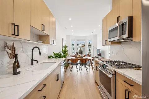 a kitchen with stainless steel appliances a sink a stove top oven a counter space and cabinets