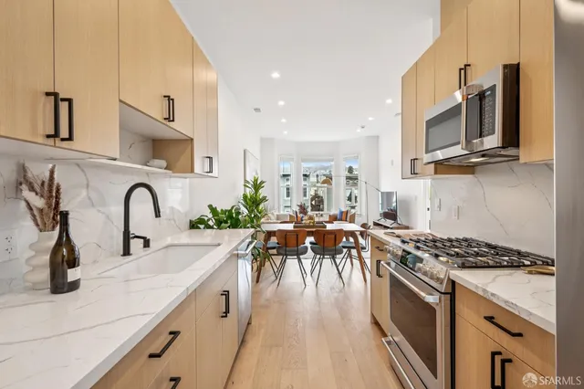 a kitchen with stainless steel appliances a sink a stove top oven a counter space and cabinets