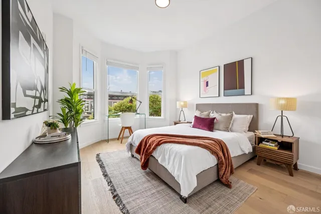 a bedroom with a large bed and a potted plant