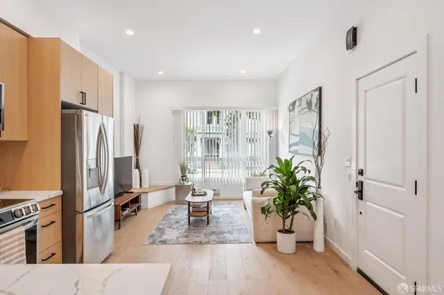 a living room with furniture potted plant and refrigerator