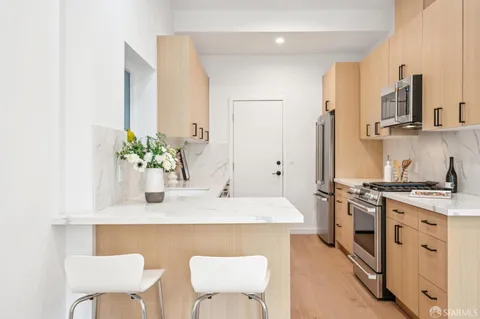 a kitchen with stainless steel appliances granite countertop a white cabinets and a stove