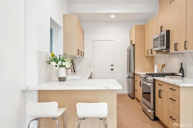 a kitchen with stainless steel appliances granite countertop a white cabinets and a stove