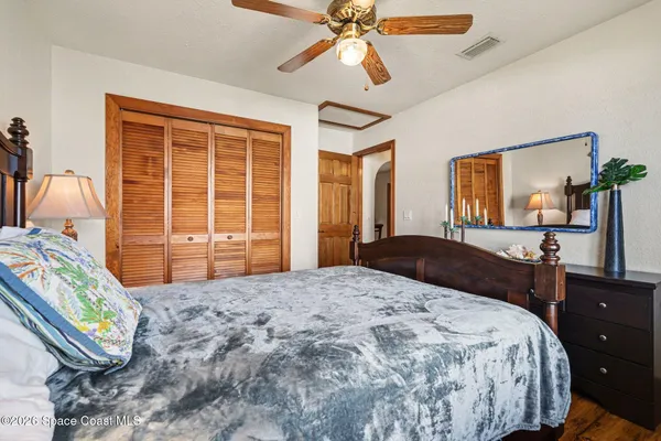 a bedroom with a bed and wooden floor