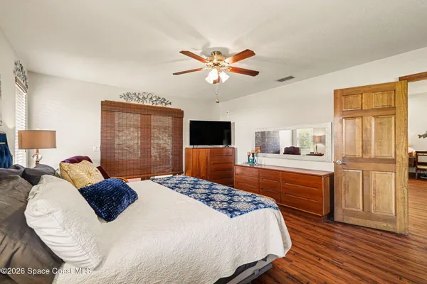 a bedroom with a bed and wooden floor
