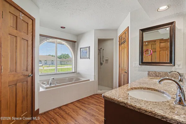 a bathroom with a granite countertop sink a toilet and a shower