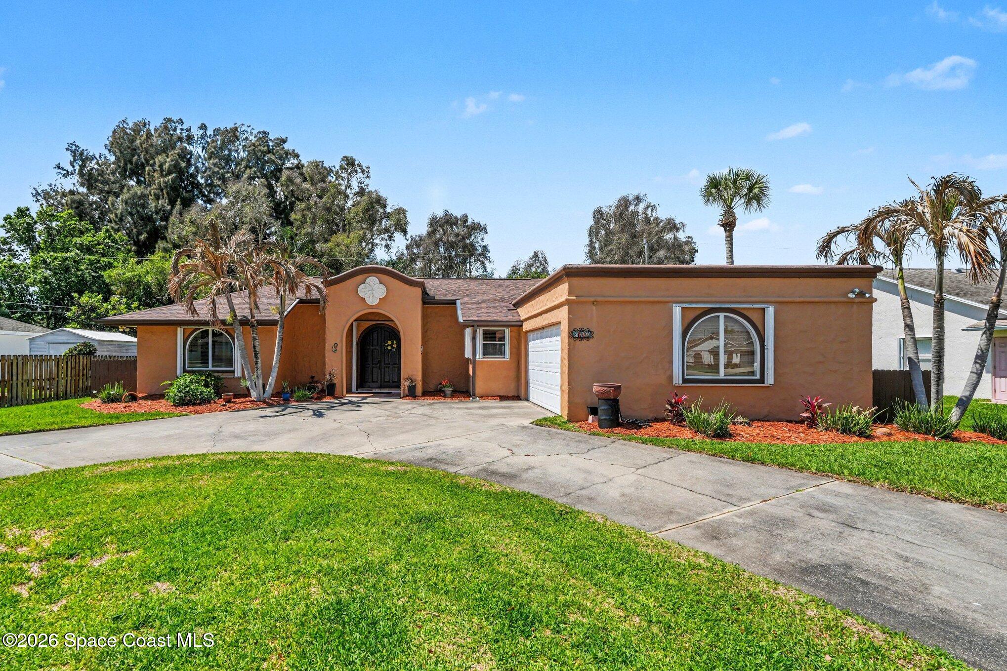 2604 Senator Way Melbourne, FL 32901 - Photo 2 of 27 a front view of a house with a yard and garage