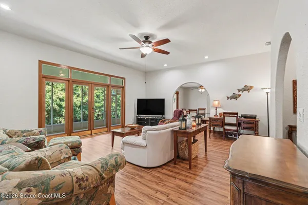a dining room with furniture a chandelier and wooden floor