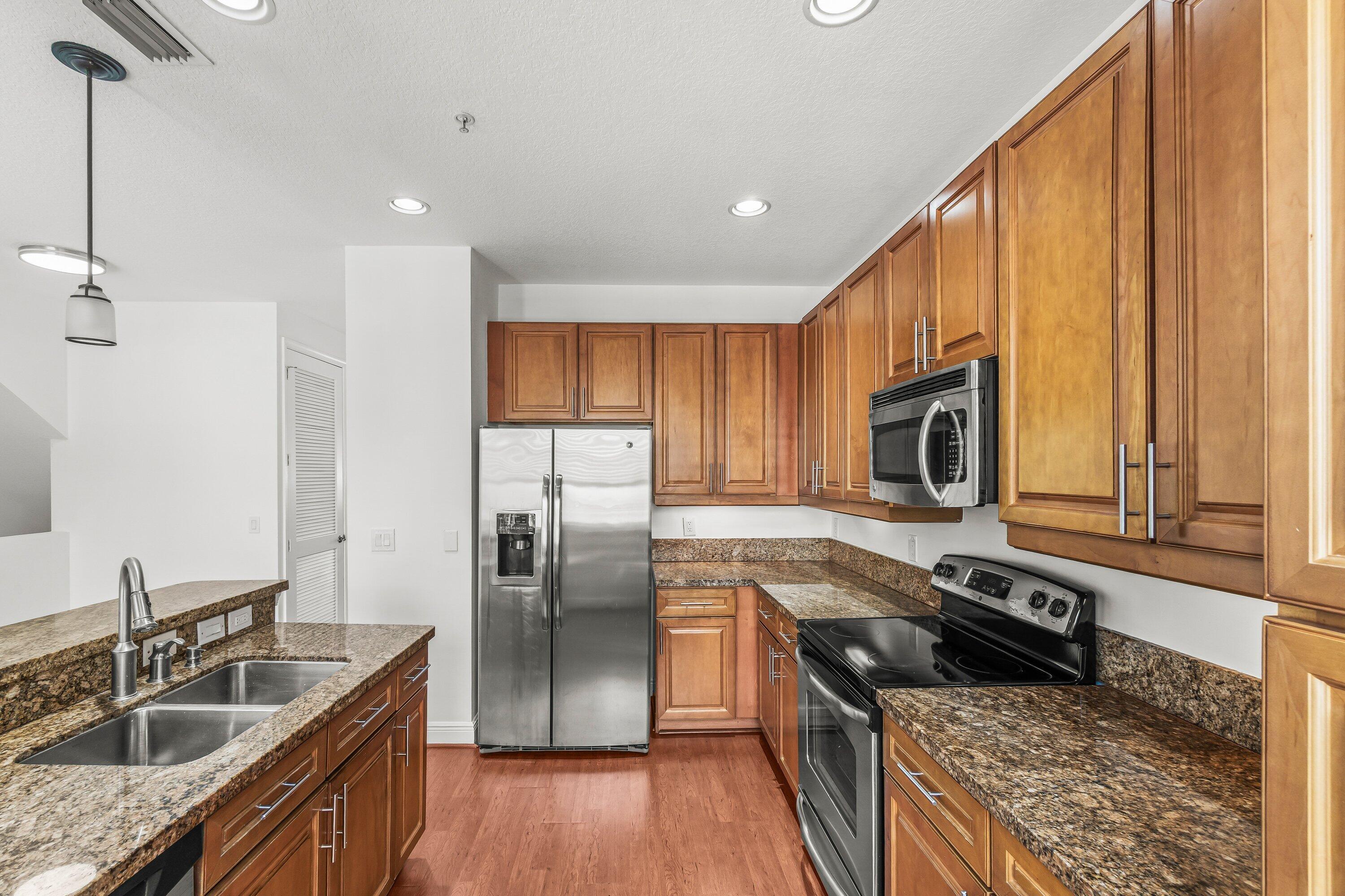 3830 Northwest 5th Terrace Boca Raton, FL 33431 - Photo 12 of 30 a kitchen with stainless steel appliances granite countertop a sink a stove and a refrigerator