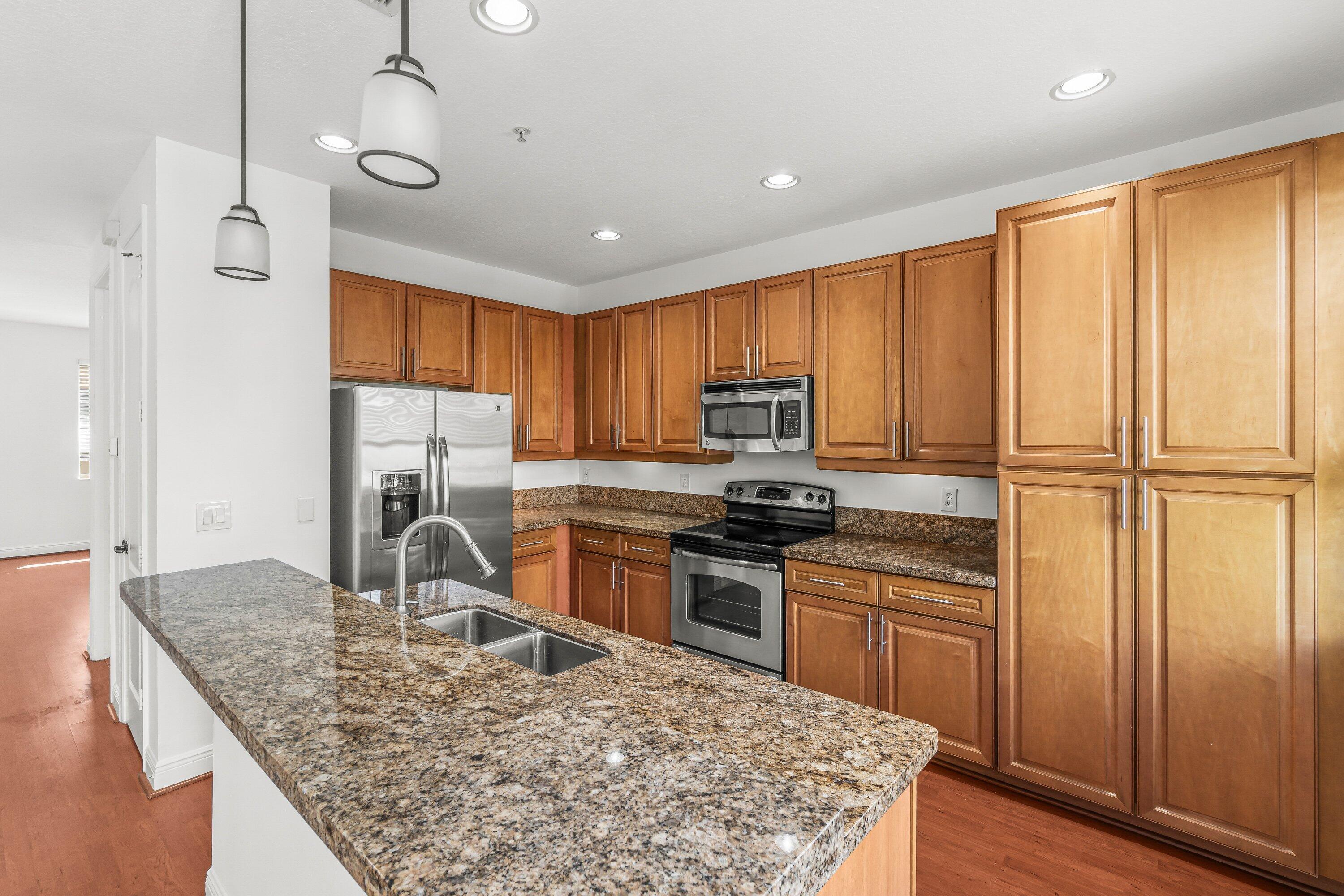 3830 Northwest 5th Terrace Boca Raton, FL 33431 - Photo 13 of 30 a kitchen with stainless steel appliances granite countertop a refrigerator a stove top oven a sink and dishwasher