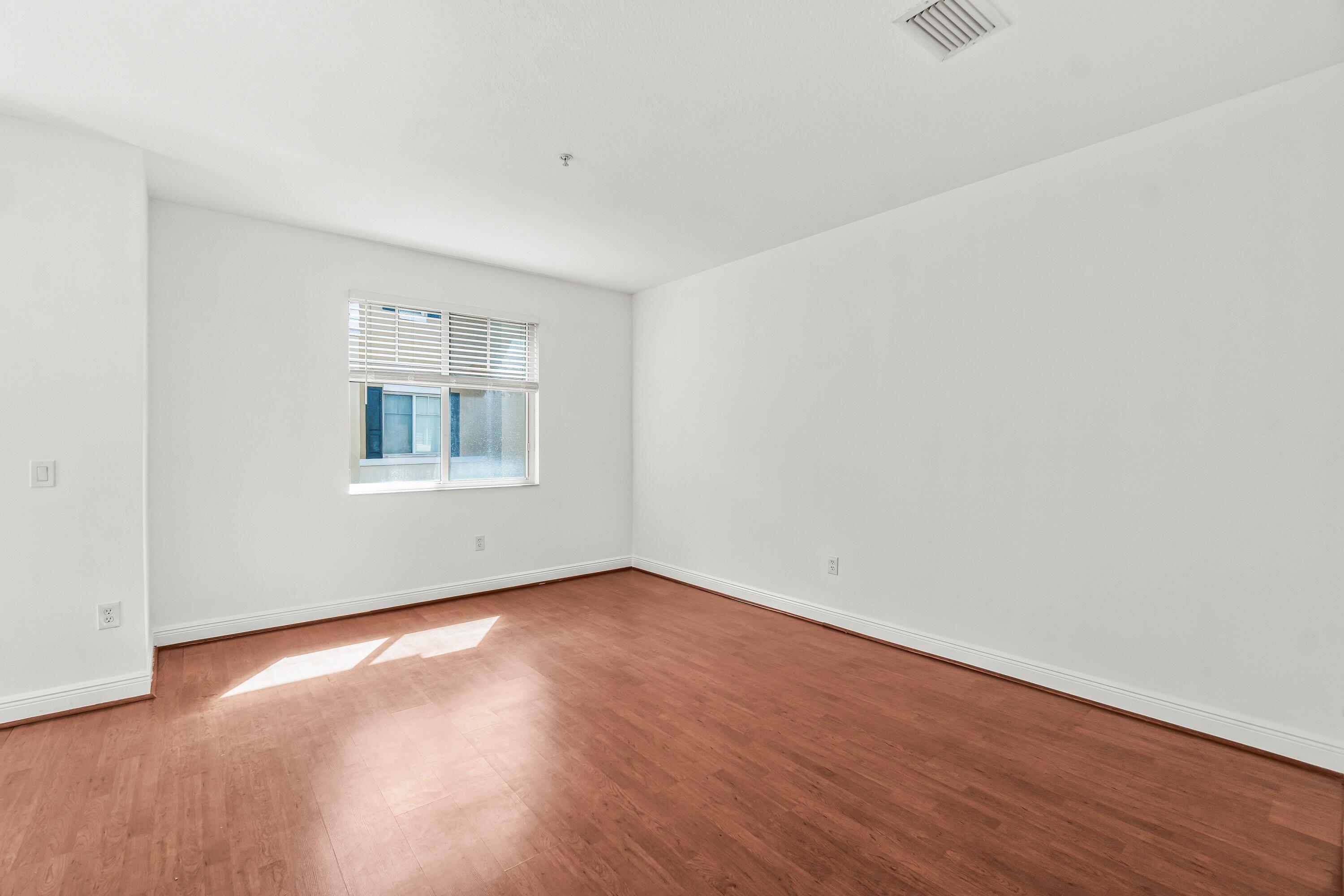 3830 Northwest 5th Terrace Boca Raton, FL 33431 - Photo 18 of 30 an empty room with wooden floor and windows
