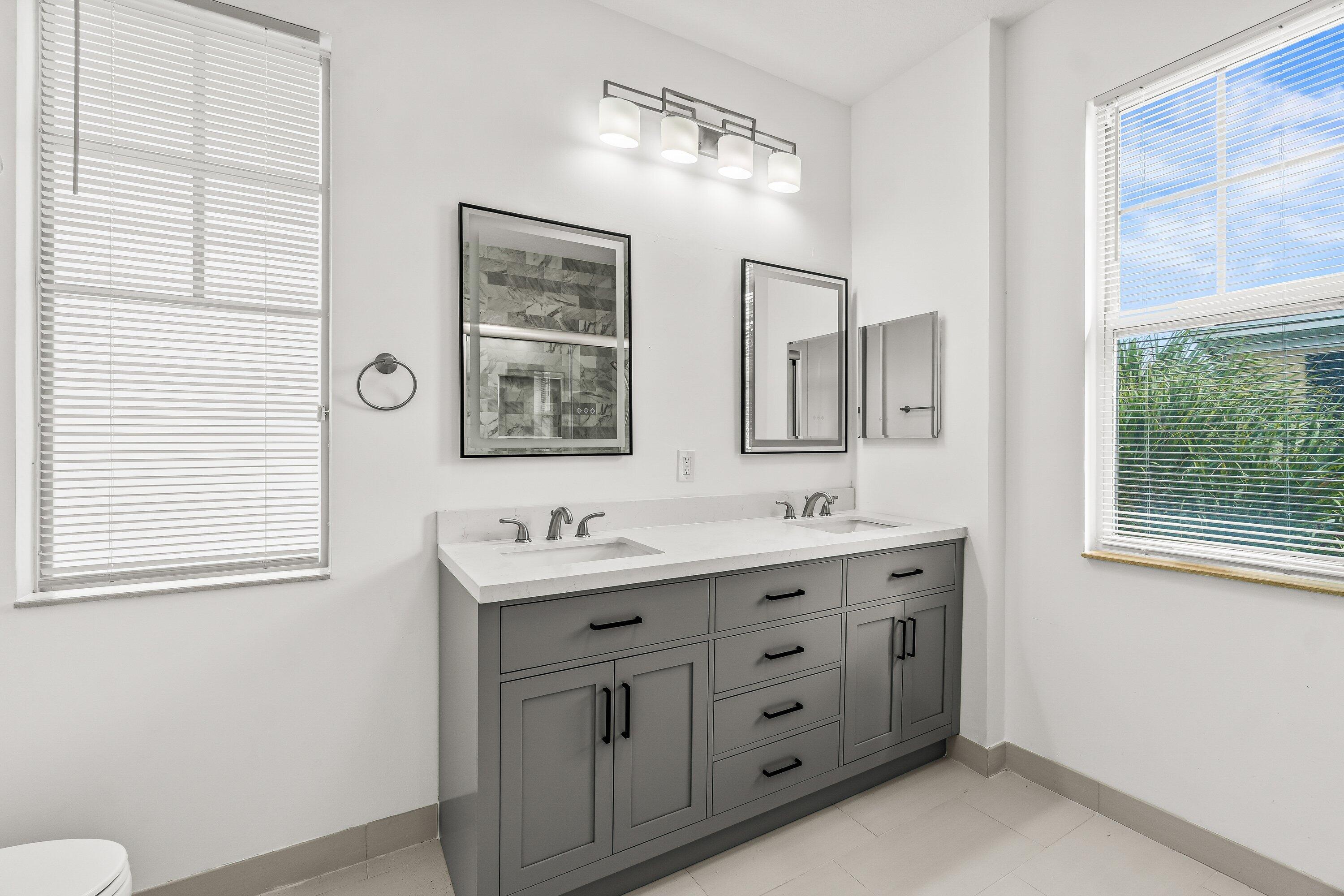 3830 Northwest 5th Terrace Boca Raton, FL 33431 - Photo 29 of 30 a bathroom with double sink and a mirror