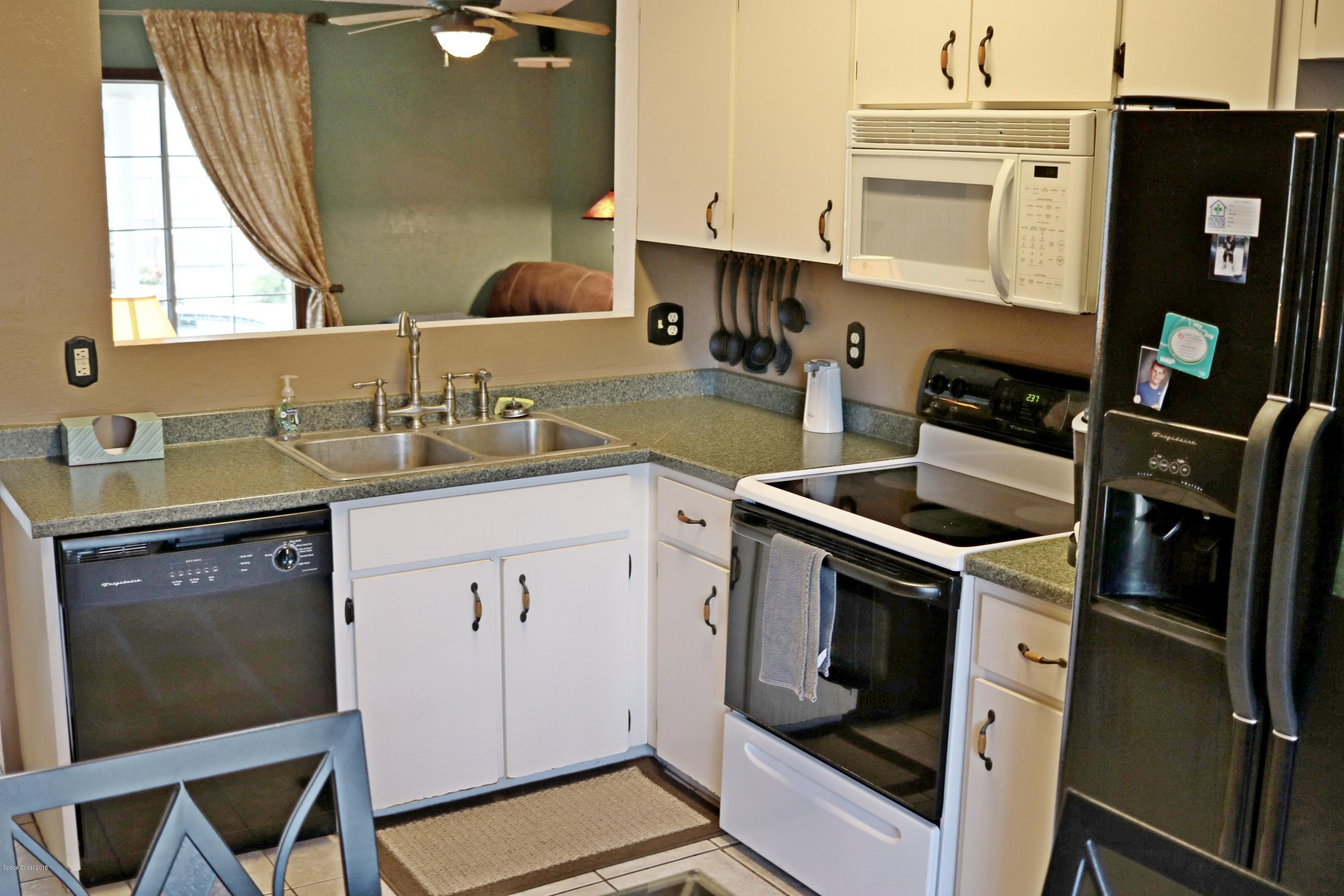 6154 Corning Road Cocoa, FL 32927 - Photo 2 of 16 a kitchen with a sink stove and cabinets