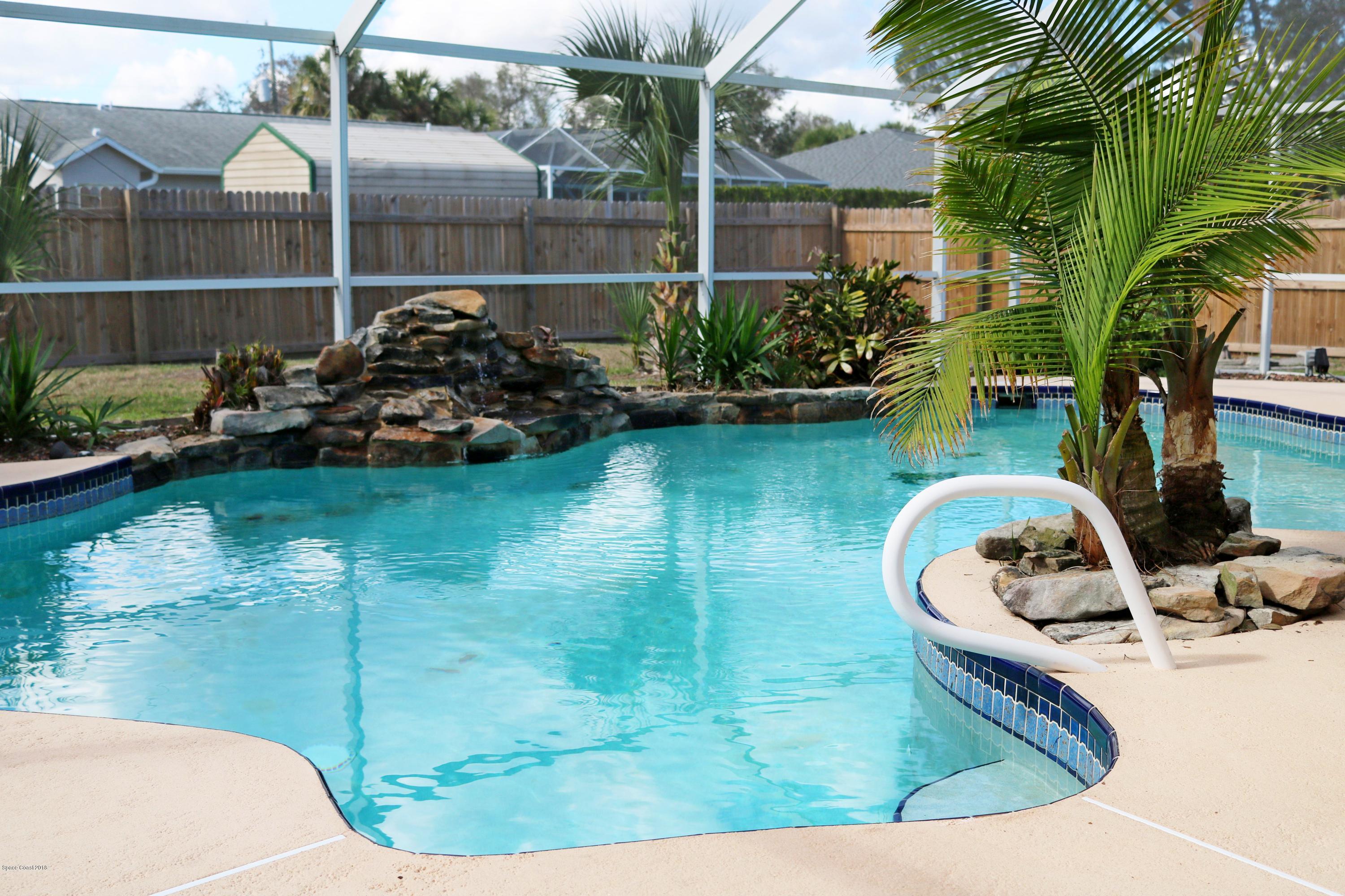 6154 Corning Road Cocoa, FL 32927 - Photo 12 of 16 a view of a backyard with plants and swimming pool