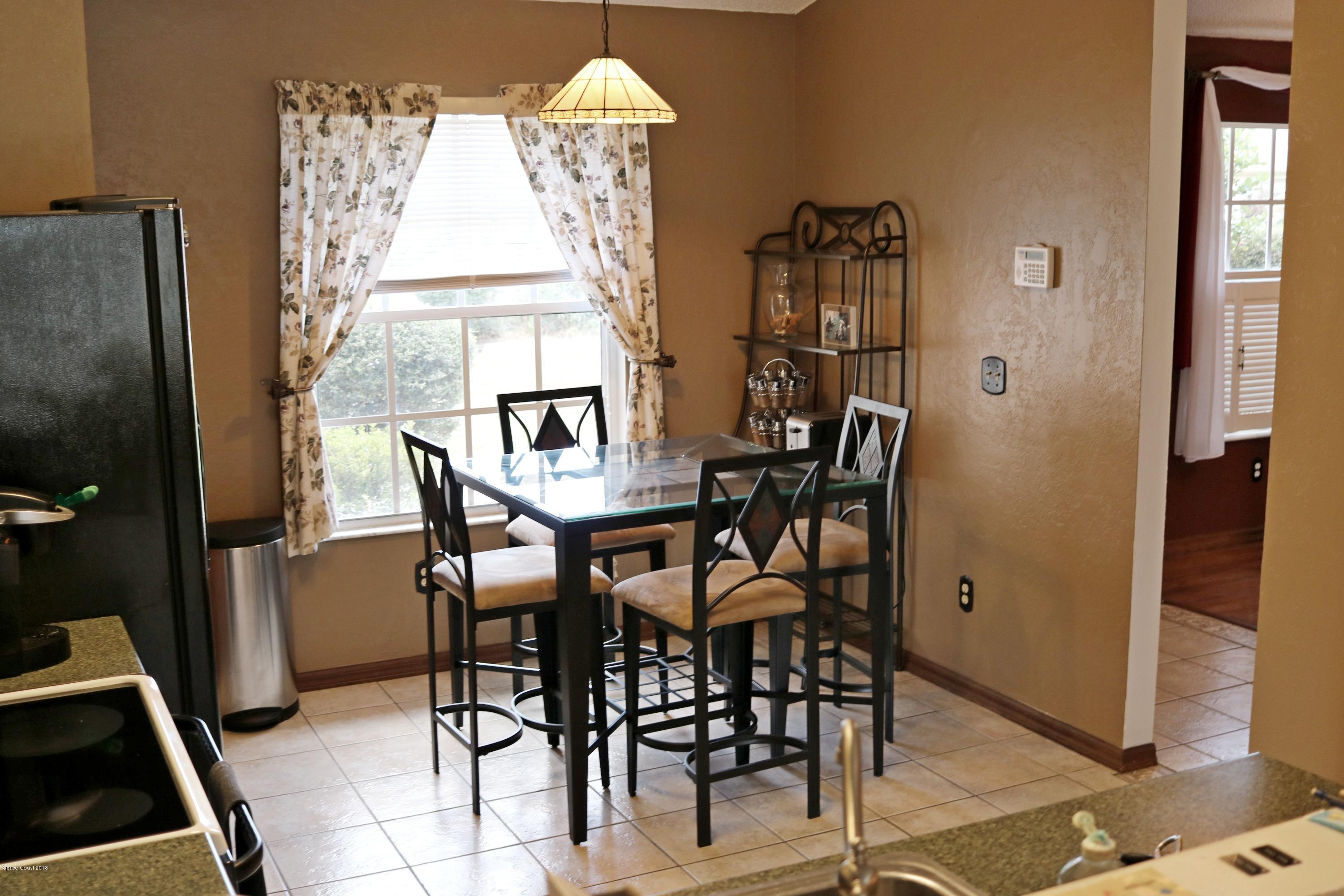 6154 Corning Road Cocoa, FL 32927 - Photo 3 of 16 a view of a dining room with furniture and chandelier