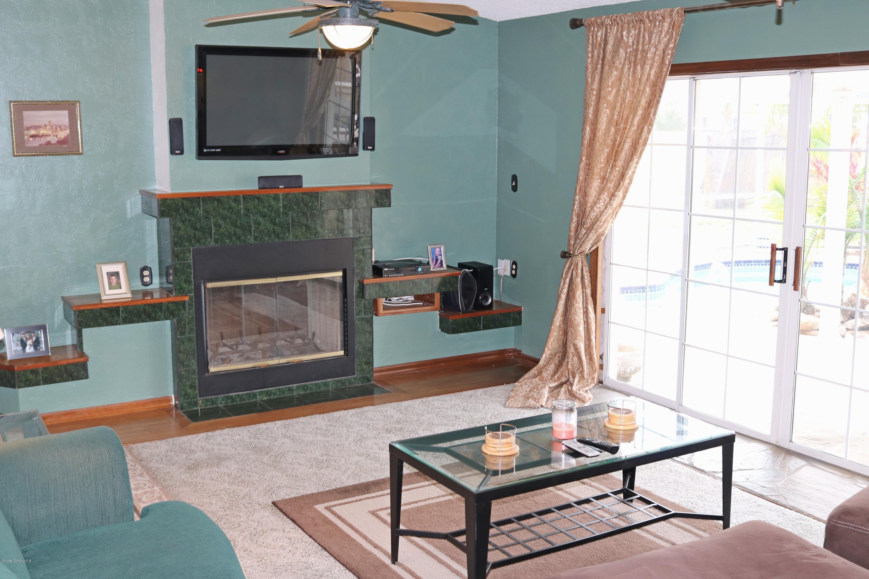 6154 Corning Road Cocoa, FL 32927 - Photo 5 of 16 a living room with furniture and a fireplace