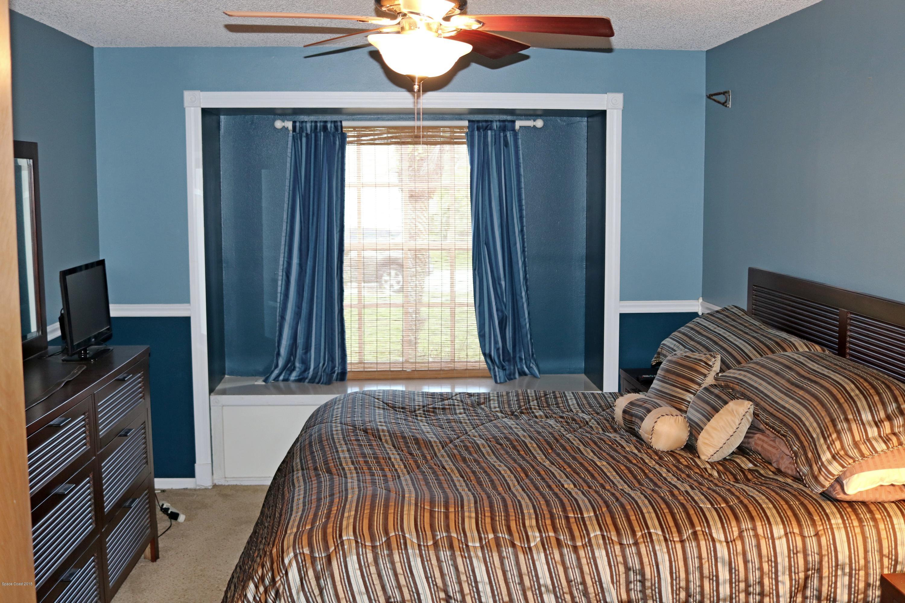 6154 Corning Road Cocoa, FL 32927 - Photo 8 of 16 a bedroom with a bed and a window
