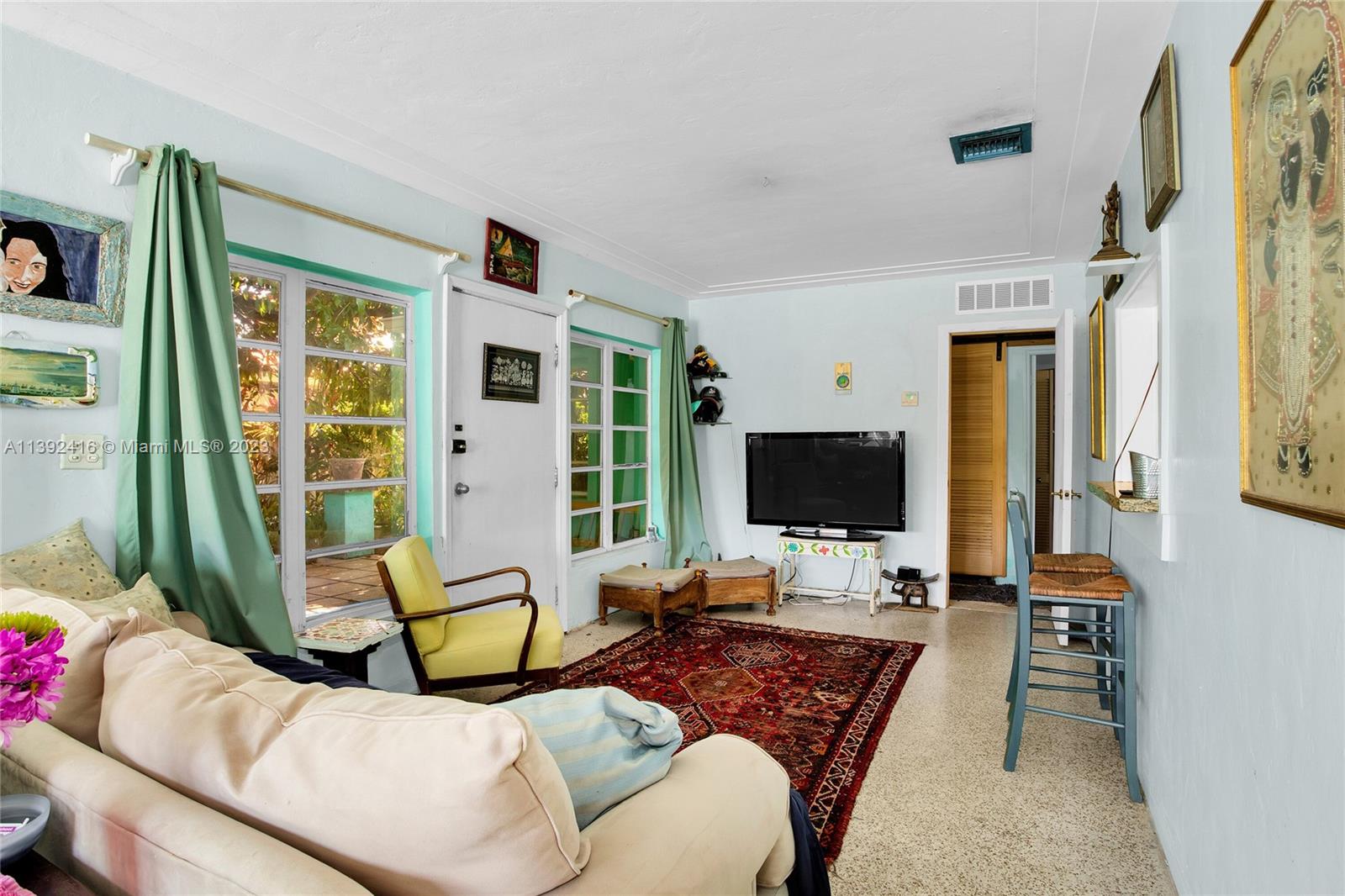 1541 Calais Drive Miami Beach, FL 33141 - Photo 12 of 33 a living room with furniture large window and flat screen tv