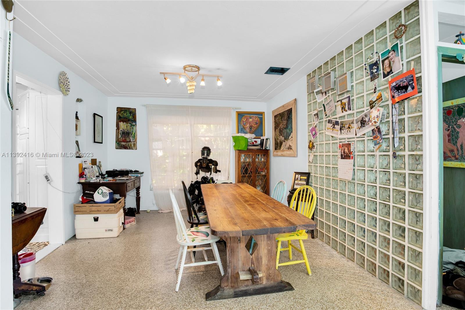 1541 Calais Drive Miami Beach, FL 33141 - Photo 15 of 33 a view of a dining room with furniture and a chandelier fan
